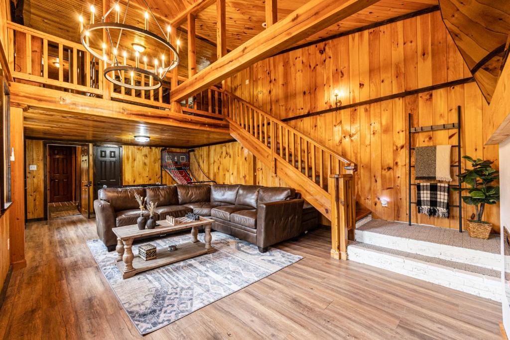 a living room with a couch and a staircase at Peaceful cabin w/ hot tub, pool table & fire pit - BIG BLUE in Bryson City