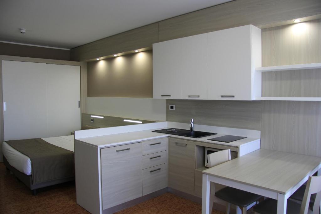 a kitchen with a sink and a bed in a room at Residence all'Adige in Verona