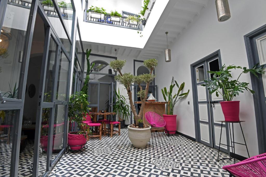 an indoor courtyard with plants and pink chairs at Riad CK Medina in Marrakech