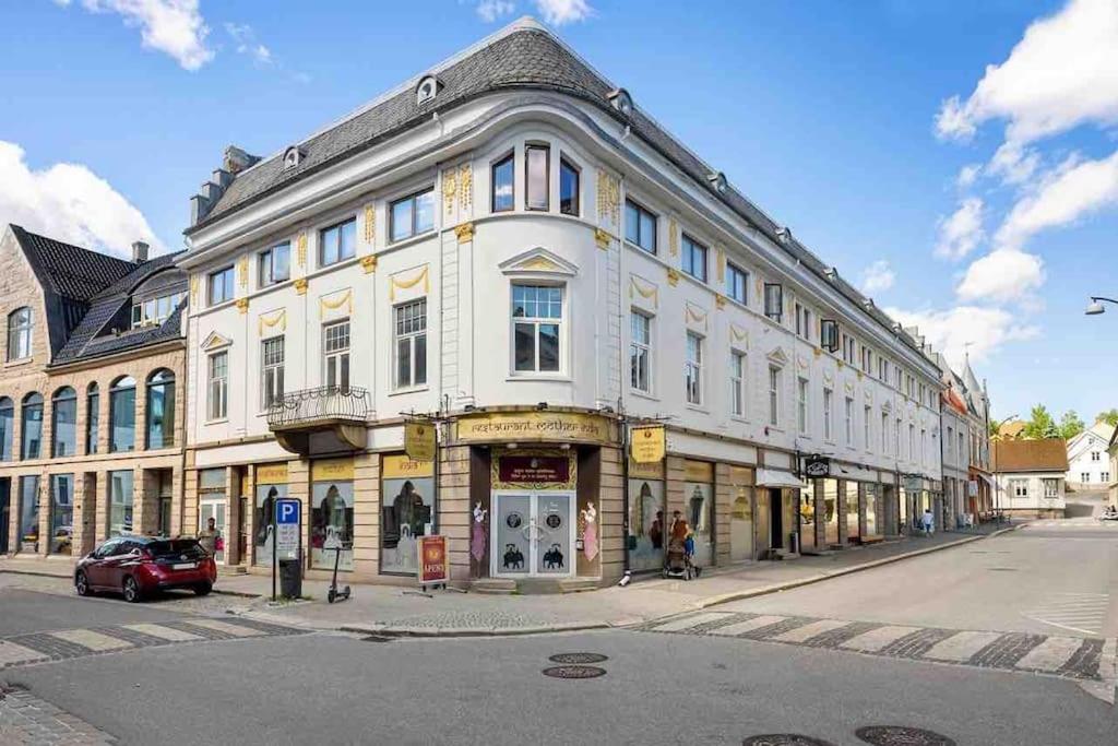 Moderne leilighet midt i sentrum av Fredrikstad في فريدريكستاد: مبنى ابيض كبير على زاوية شارع