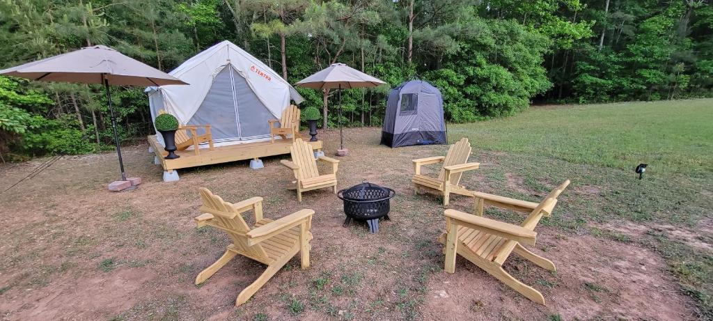 a group of chairs and a tent in a field at Tentrr Signature Site - Glamping in The Hamptons in Hampton