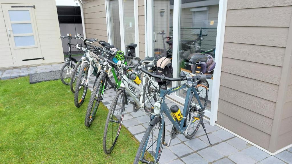 eine Reihe von Fahrrädern, die an der Seite eines Hauses geparkt sind in der Unterkunft Luxe cottage met fietsen, airco & infrarood cabine in Knokke-Heist