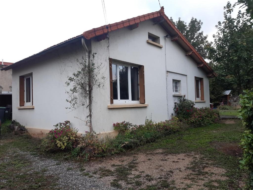 une maison blanche avec une fenêtre sur le côté de celle-ci dans l'établissement Petite maison très paisible avec jardin à Cournon - Puy de Dôme !, à Le Cendre