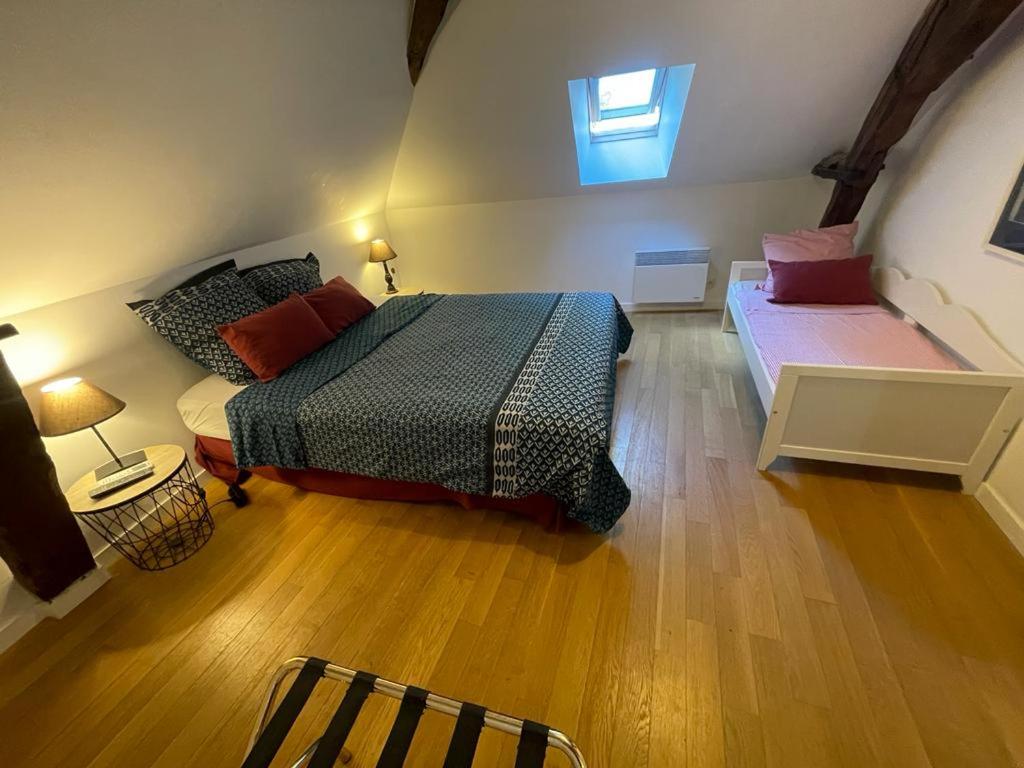 a bedroom with a bed and a couch and a window at Gîte de la Mignonerie du Château de Jallanges pour 19 personnes avec 4 ou 7 chambres in Vernou-sur-Brenne