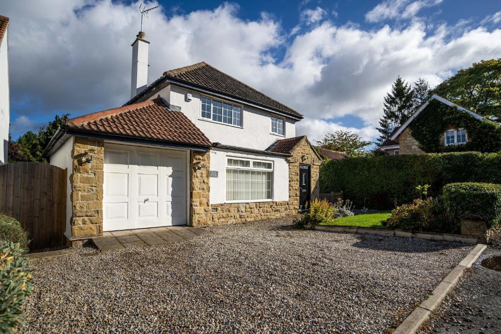 a detached house with a white garage at Beautiful detached home in quaint village setting in Wetherby