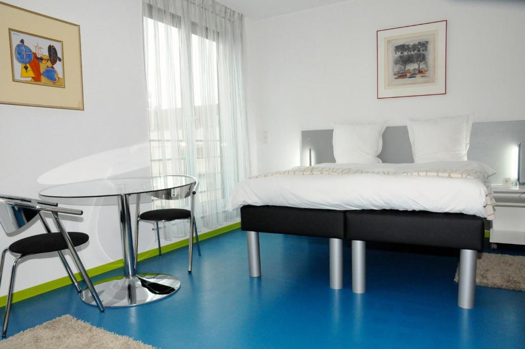 a bedroom with a bed and a glass table at Domus Hotel in Luxembourg