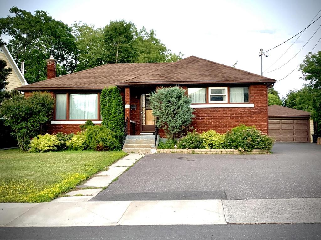 a brick house with a driveway in front of it at Charming Home Away from Home in Thunder Bay