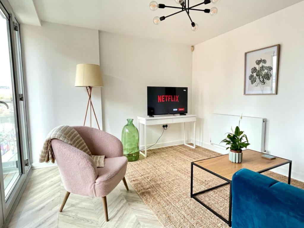 a living room with a chair and a tv at Central Shoreditch Flat By Box Park & Spitalfields Market in London