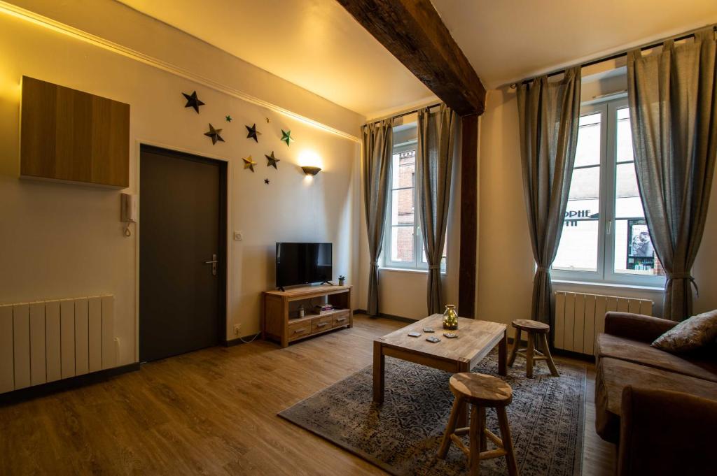 ein Wohnzimmer mit einem Tisch und Sternen an der Wand in der Unterkunft Appartement Cosy Au Sein De La Venise Normande in Pont-Audemer