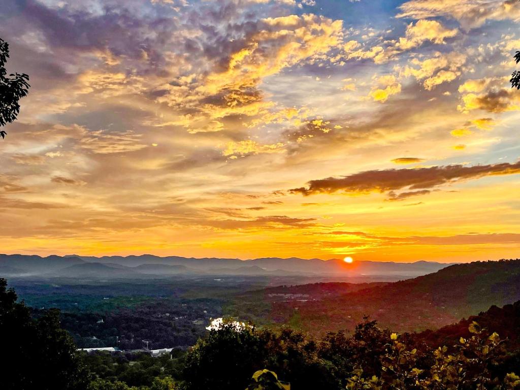 una puesta de sol en las montañas con la puesta de sol en Sunset Sanctuary, en Asheville