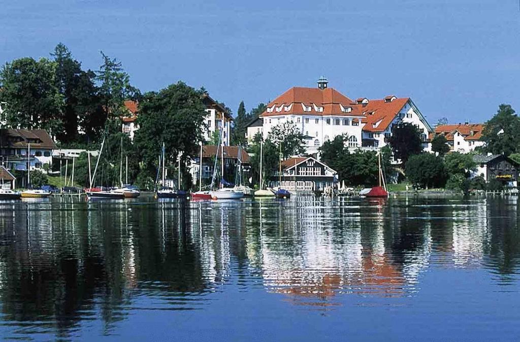 a group of boats on a lake with houses at Seeresidenz Alte Post in Seeshaupt