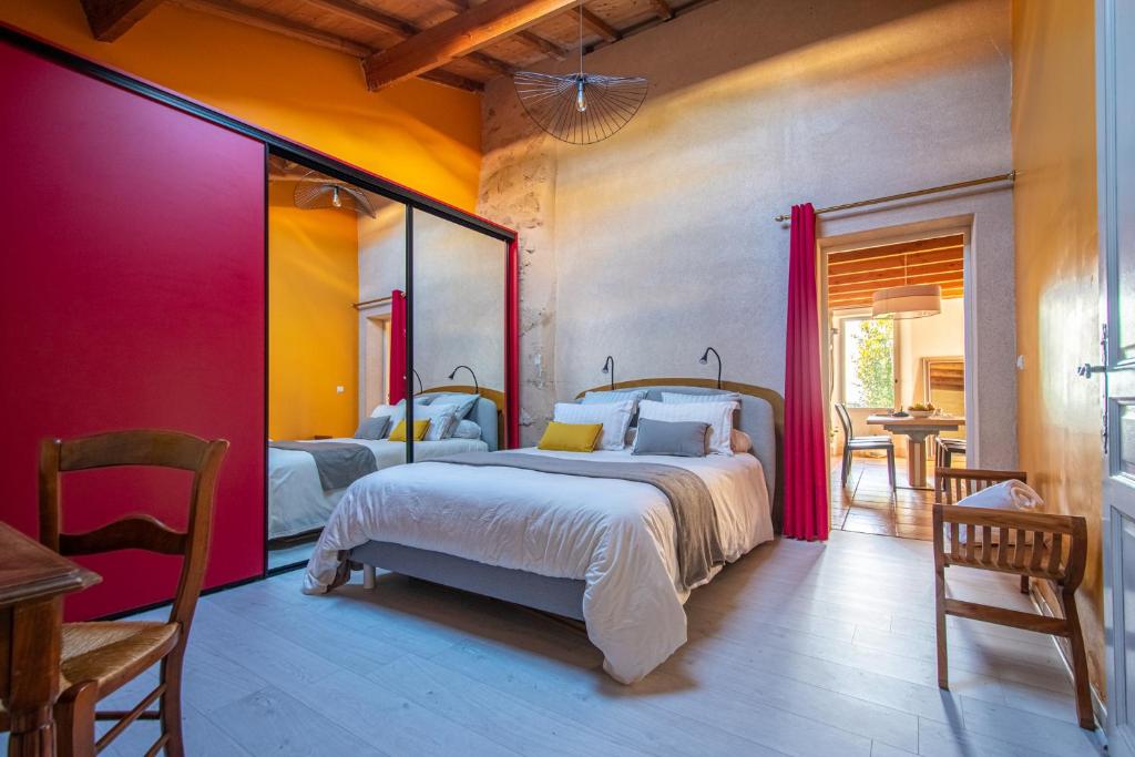 1 dormitorio con 2 camas, mesa y sillas en Ô FIL DE L ISLE, en Savignac-sur-lʼIsle