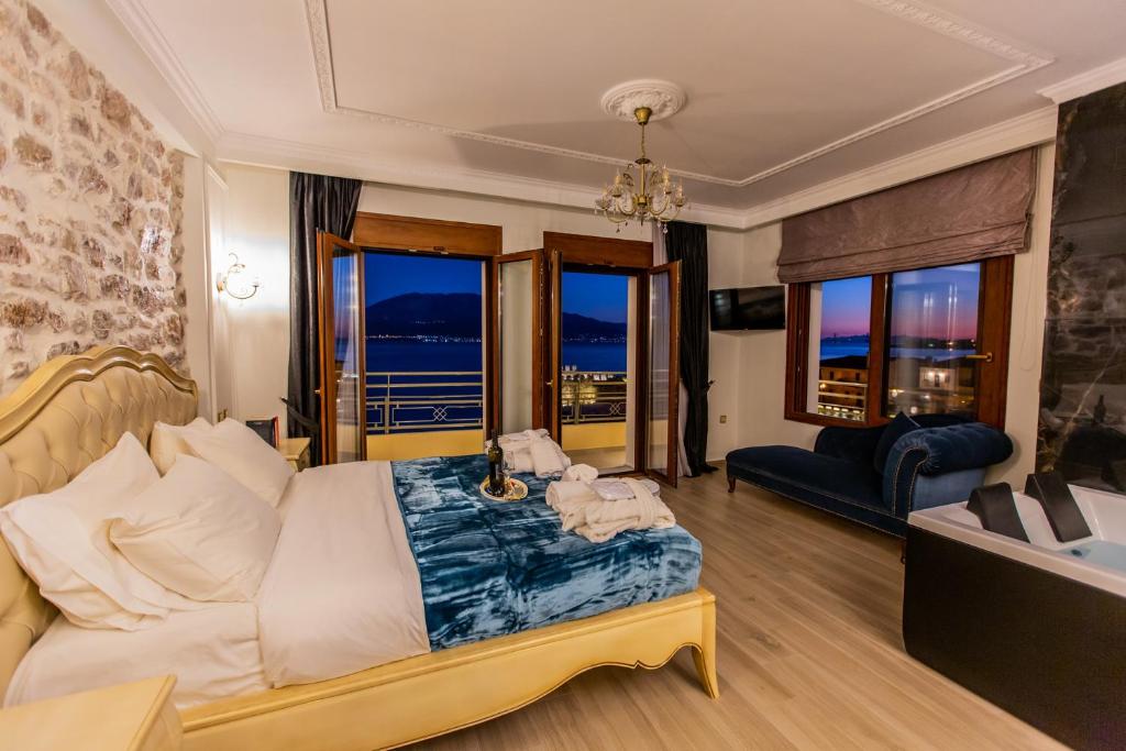 una camera con letto, divano e finestre di Vip Lepanto Port Suites a Nafpaktos