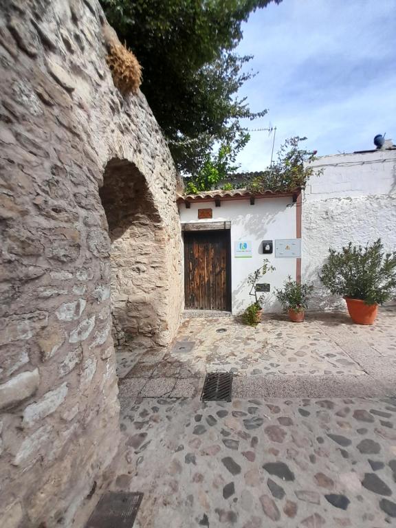 a stone building with a doorway and a door at Casa Pozo de la Nieve in Iznatoraf