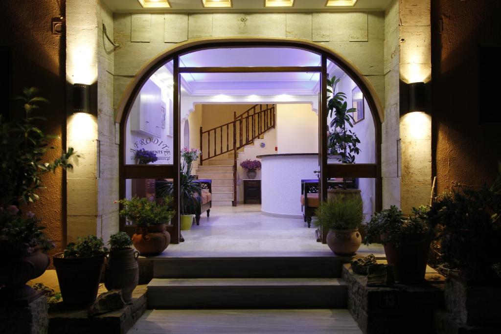 une entrée à un bâtiment avec des plantes en pot dans l'établissement Afrodite Hotel Apartments, à Mirina