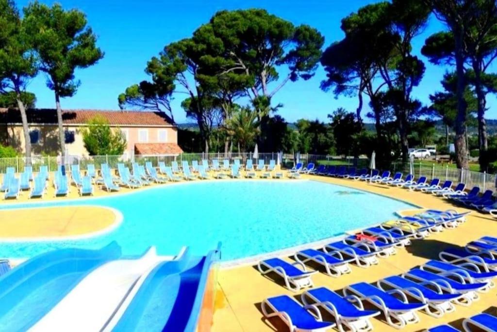 a large swimming pool with chairs and lawn chairs at Villa L'Occitane in Calvisson