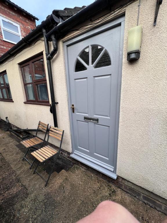 a door to a house with two chairs next to it at Amaya Two - Spacious, ground floor apartment with a large patio area. in Lincolnshire