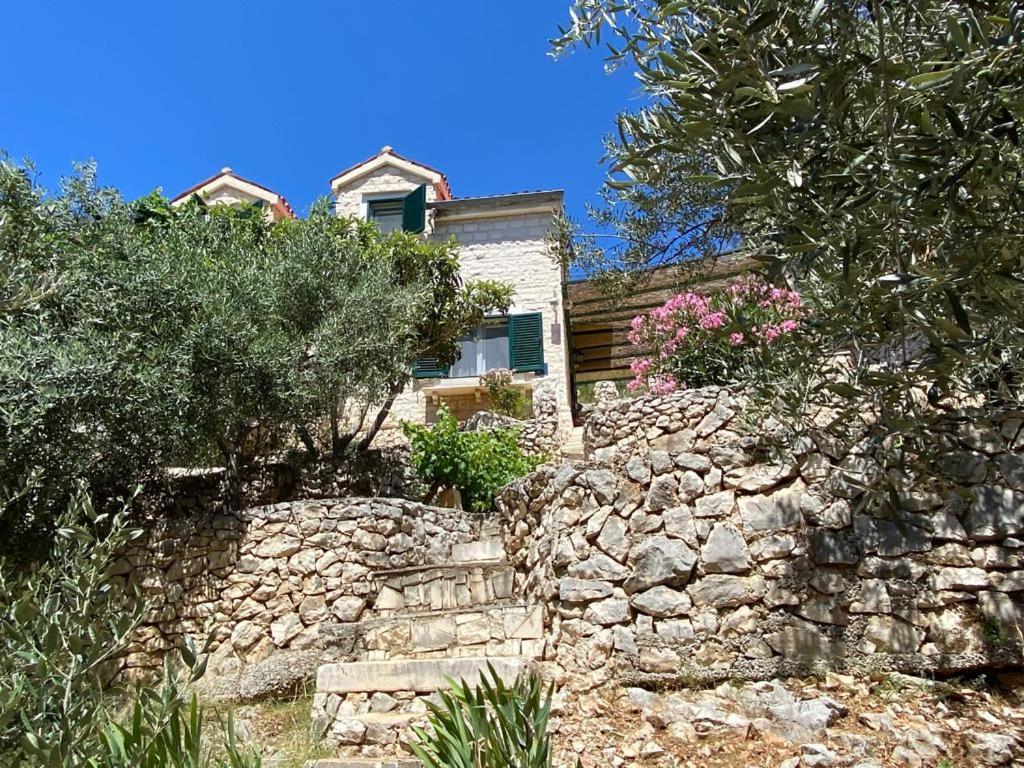 ein Steinhaus mit einer Steinmauer und Bäumen in der Unterkunft Villa Ana in Sevid