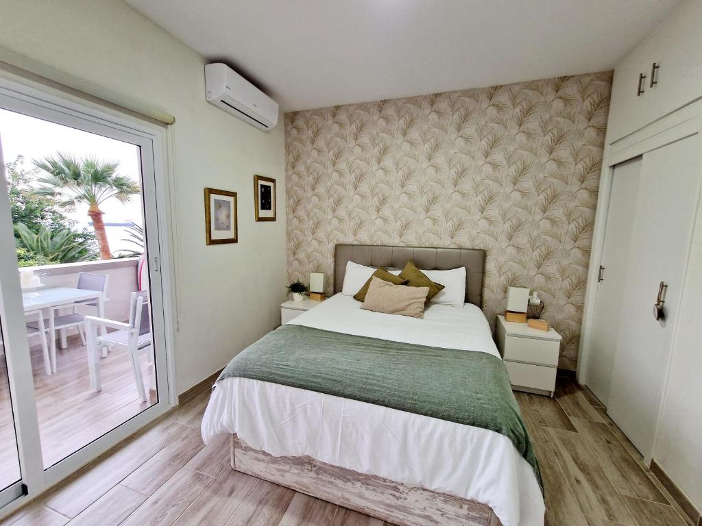 a bedroom with a large bed and a balcony at Pequeño paraíso frente al mar Playa Chica in Santa Cruz de Tenerife