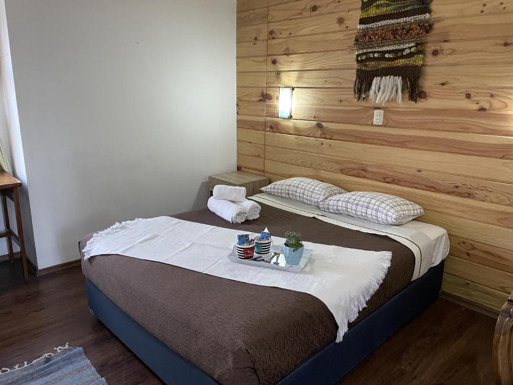 1 dormitorio con 1 cama con pared de madera en 4 Habitación Privada Cama Matrimonial, en Puerto Varas