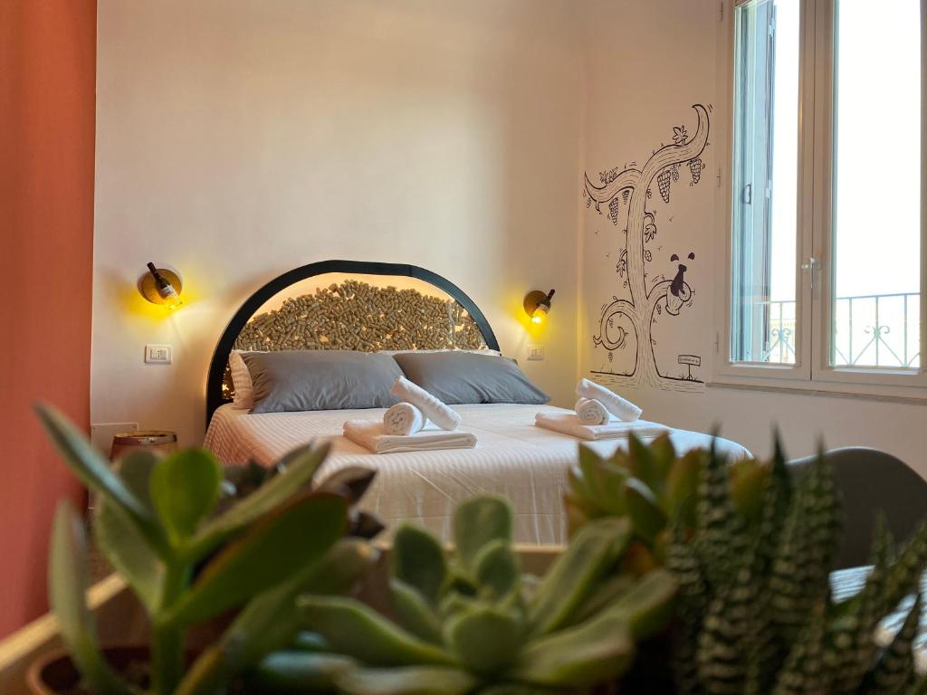 een slaapkamer met een bed met twee handdoeken erop bij Liotru Maisonne in Catania