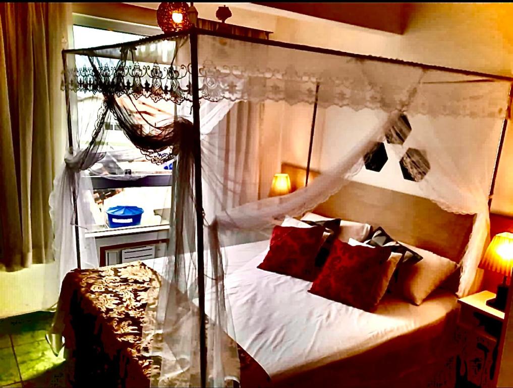 um quarto com uma cama de dossel e almofadas vermelhas em Flat bela vista master em Macaé