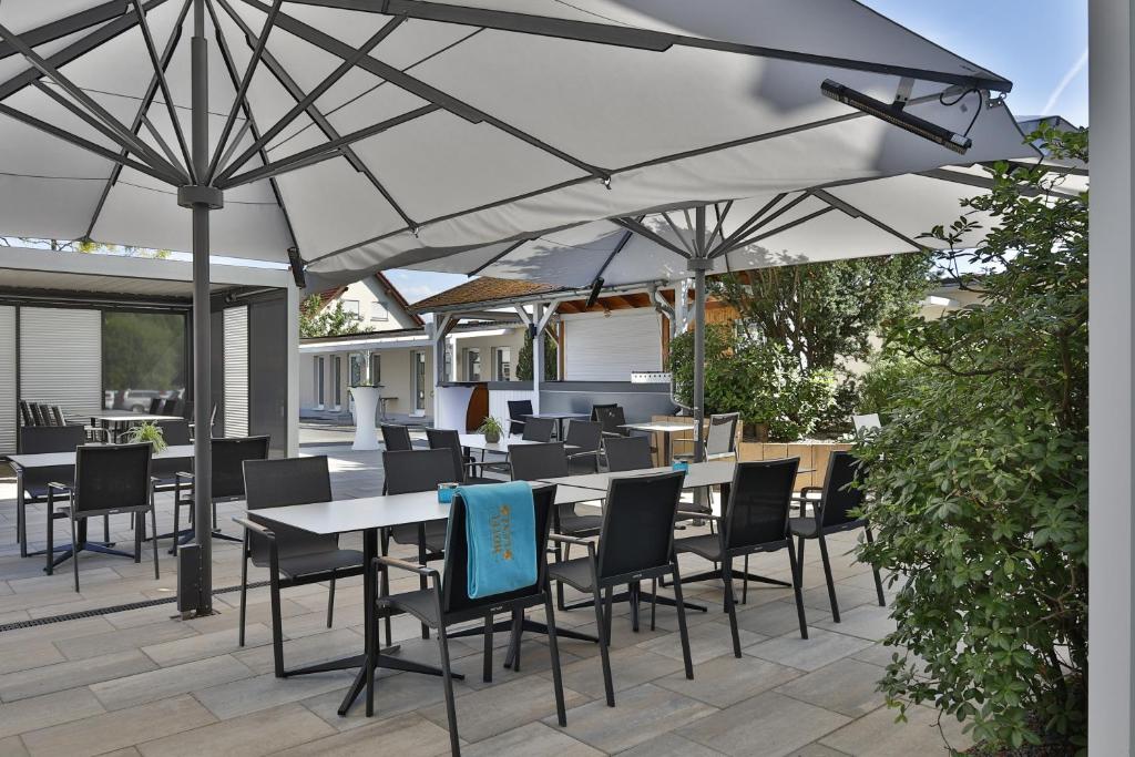 une terrasse avec des tables et des chaises sous un parasol dans l'établissement City Partner Hotel Lenz, à Fulde