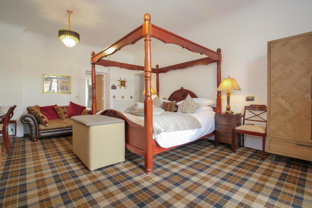 Gordonston Apartments في إينفيرنيس: غرفة نوم مع سرير بأربعة أعمدة وأريكة