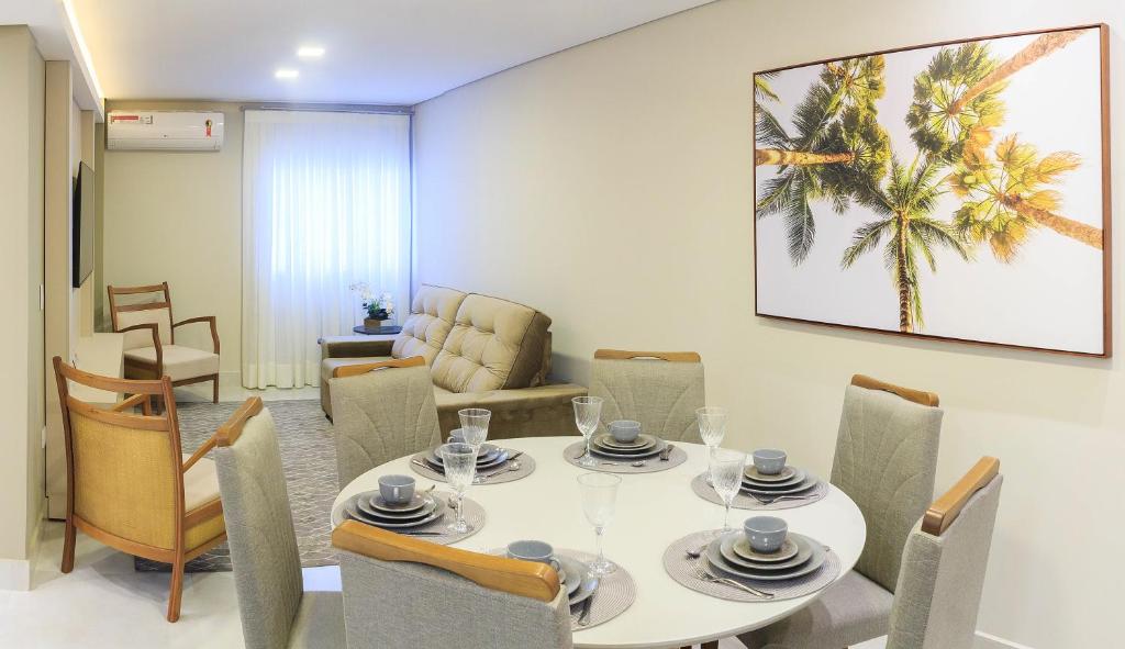 a dining room with a white table and chairs at Apto 12 - Suíte Família Próx Paraguai in Foz do Iguaçu