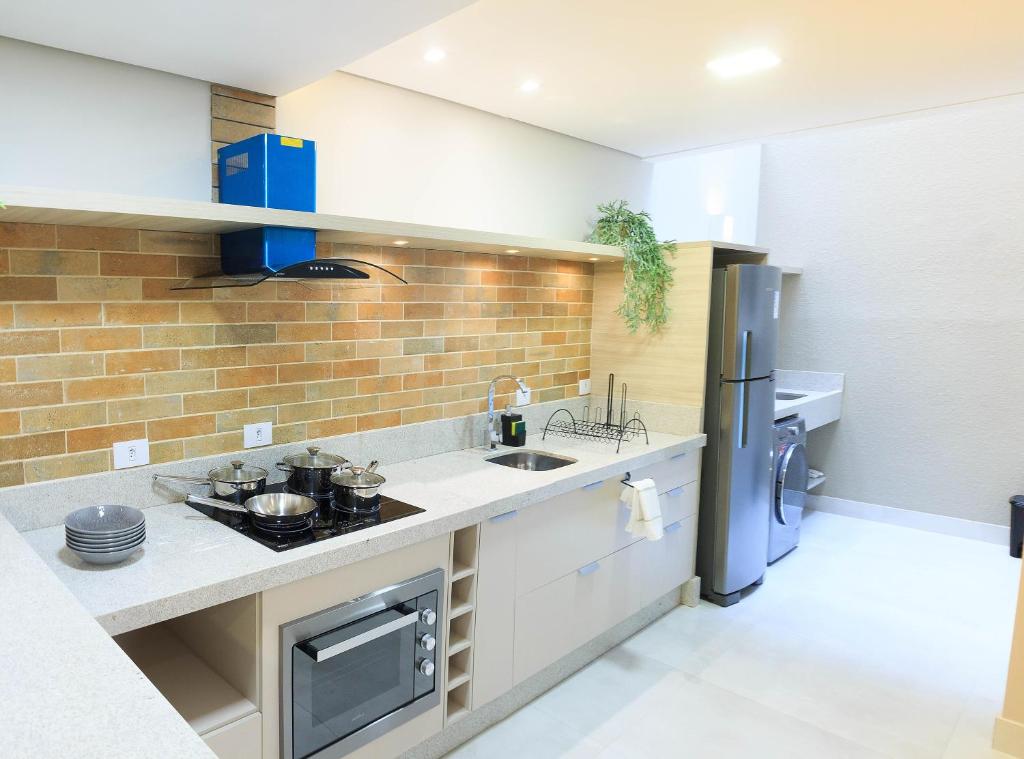 a kitchen with a sink and a refrigerator at Apartamento completo - Vila A in Foz do Iguaçu