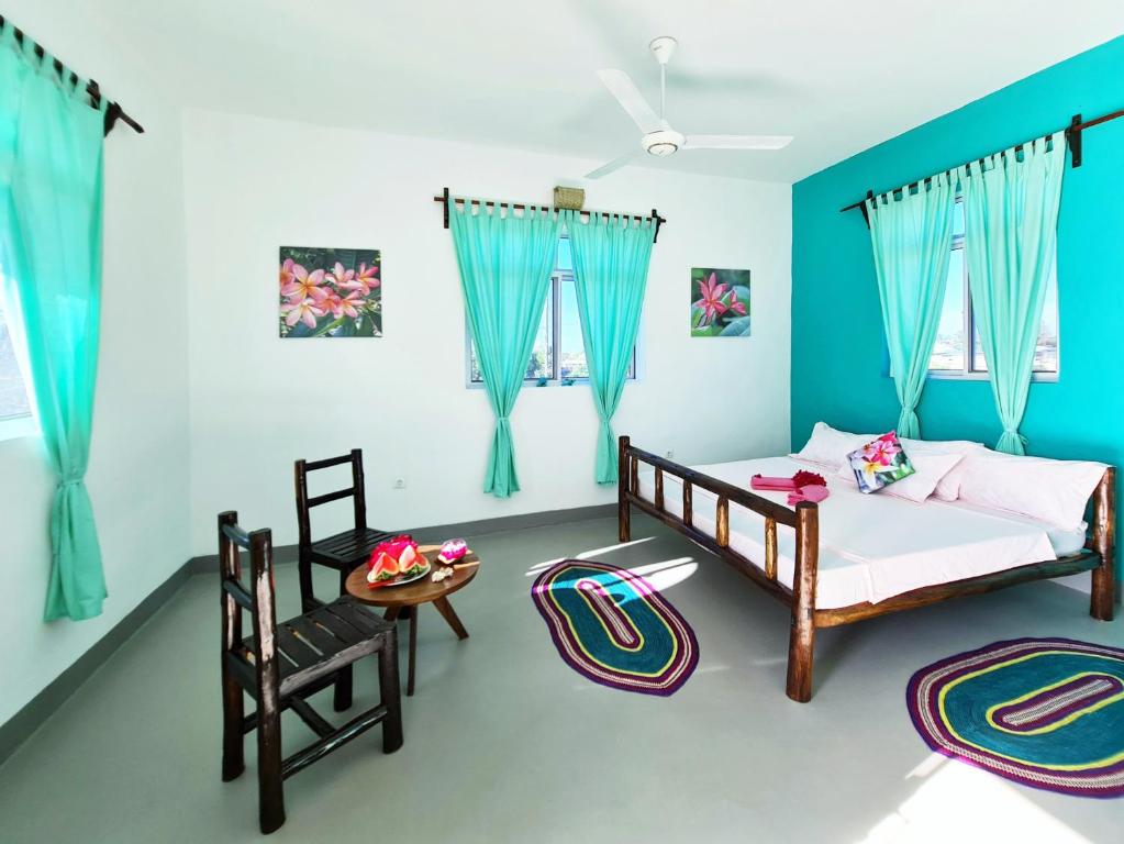 sypialnia z 2 łóżkami, stołem i krzesłami w obiekcie Frangipani House Nungwi Zanzibar w mieście Nungwi