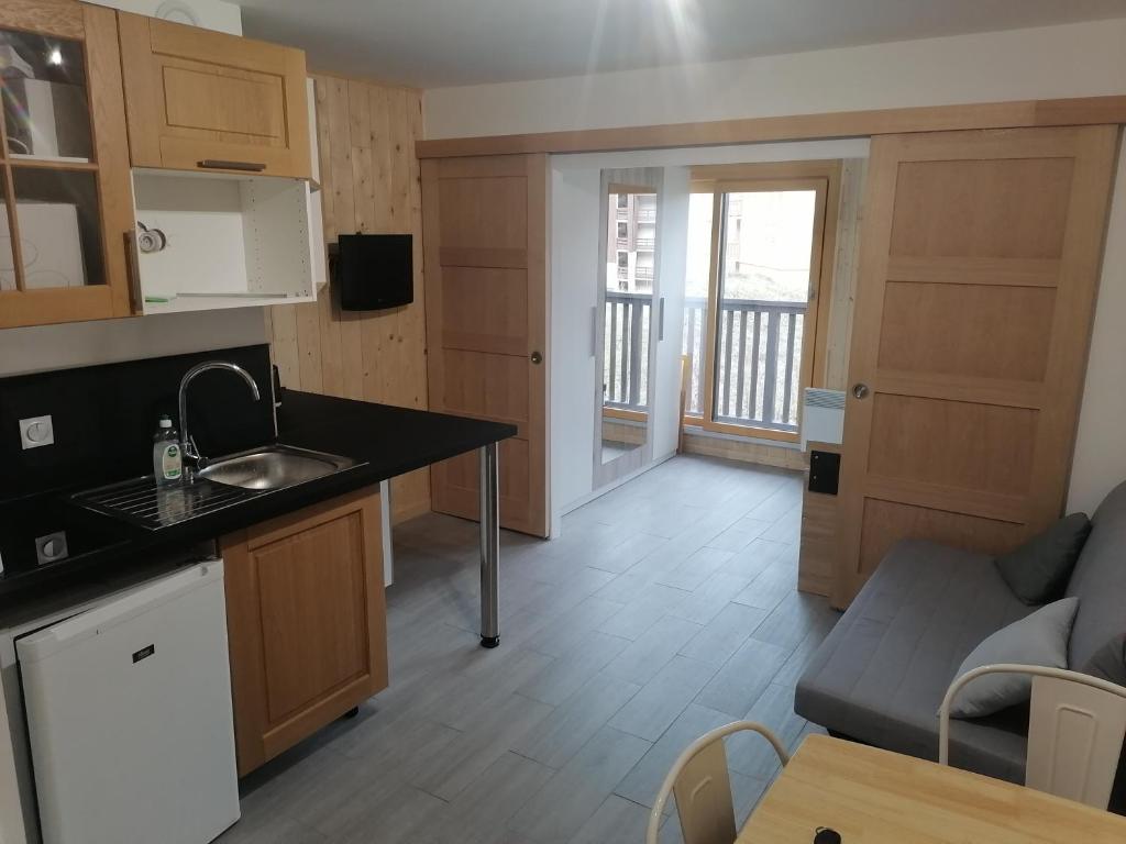 a kitchen and living room with a sink and a couch at Appartement plein sud, Val Thorens Centre in Val Thorens