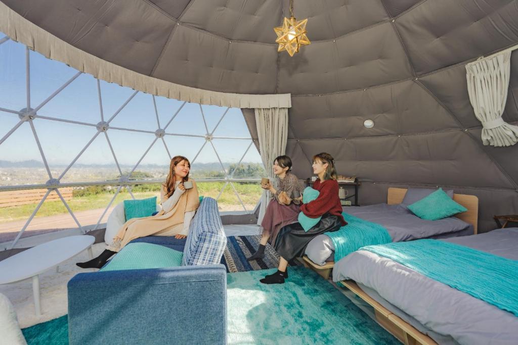 倉敷的住宿－OKAYAMA GLAMPING SORANIA - Vacation STAY 73195v，一群人坐在iguana卧室里