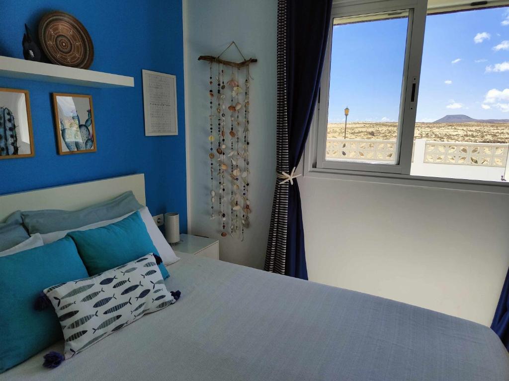 um quarto com uma cama e vista para a praia em Corralejo Dunas Pools Wifi Tennis Bikes Welcome Pack em Corralejo