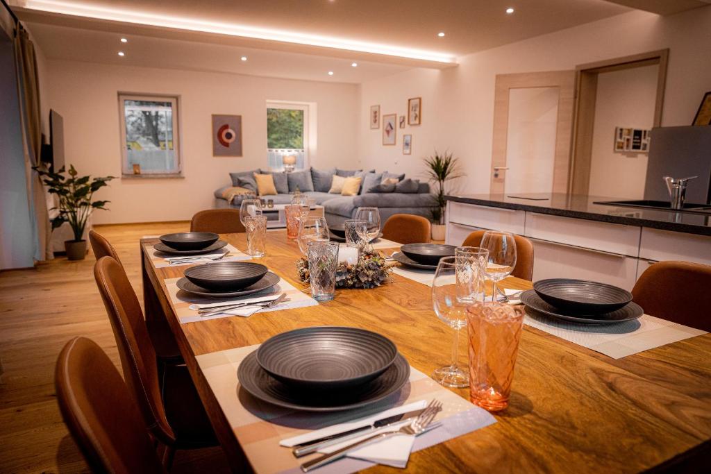 a dining room table with plates and glasses on it at Servus Apartments Premium in Vilshofen an der Donau