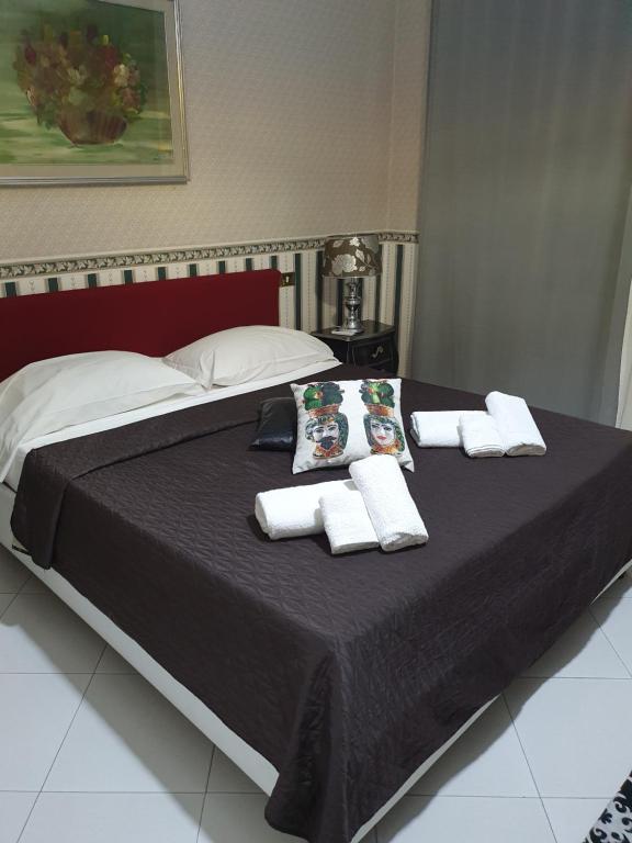 a bed with towels and pillows on top of it at Alba central City in Palermo
