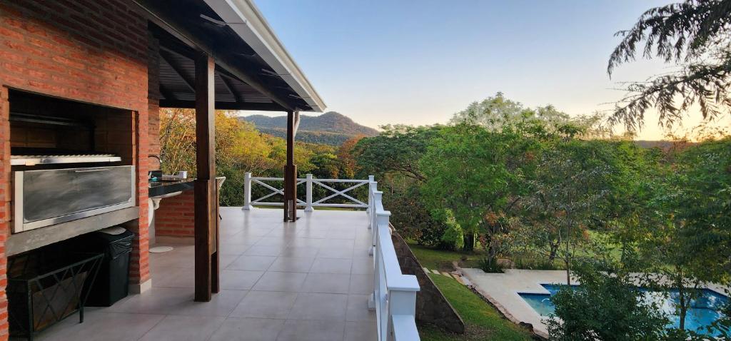 uma varanda de uma casa com vista para uma piscina em Vista Alegre Natural Resort - Villas & Cabañas em Independencia