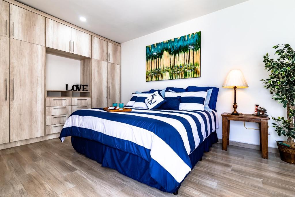 a bedroom with a bed with blue and white sheets at Milan San Marino in Tijuana