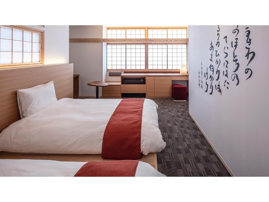 奈良市にあるHotel Tenpyo Naramachi - Vacation STAY 59515vのベッドとデスクが備わるホテルルームです。