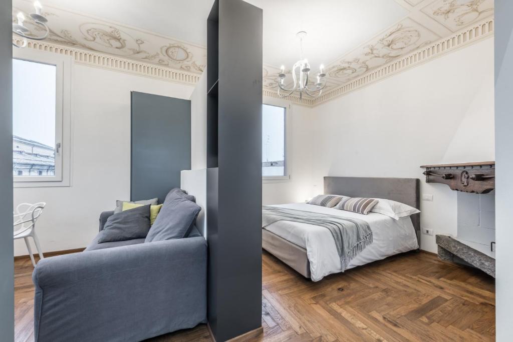 ein Schlafzimmer mit einem Bett und einem Sofa in der Unterkunft L'Altana di Emilia Suite in Modena