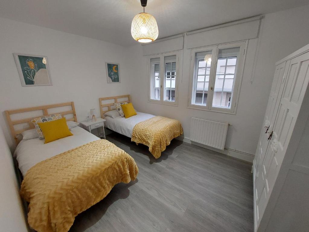 a bedroom with two beds with yellow blankets at Acea Nova 2 in Monforte de Lemos