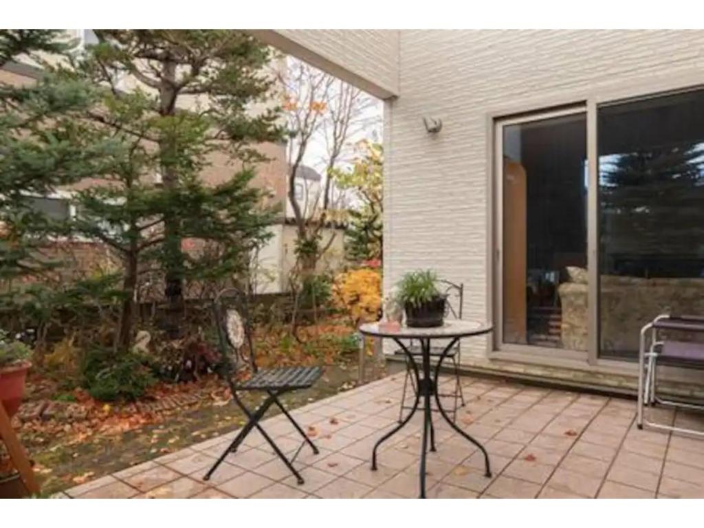 a patio with a table and a chair in front of a house at Art Salon Hosokawa - Vacation STAY 13626 in Sapporo