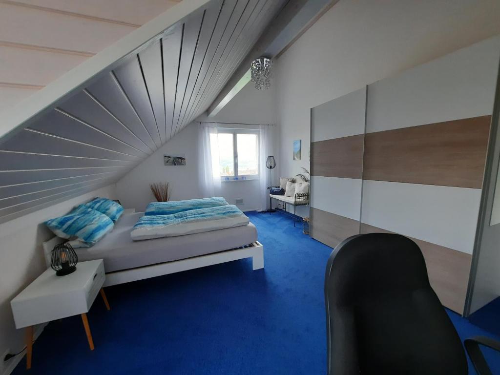 un dormitorio en el ático con una cama y una escalera en Bed & Breakfast Lake View, en Steckborn