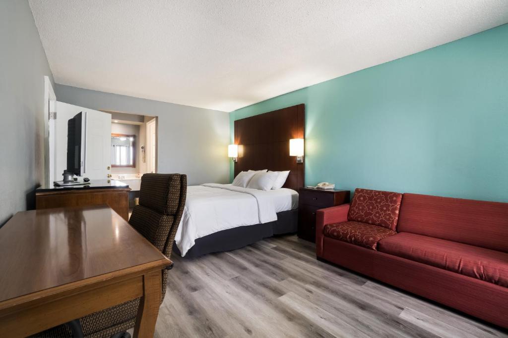 ブライズビルにあるAmericas Best Value Inn and Suites Blythevilleのベッドとソファ付きのホテルルーム