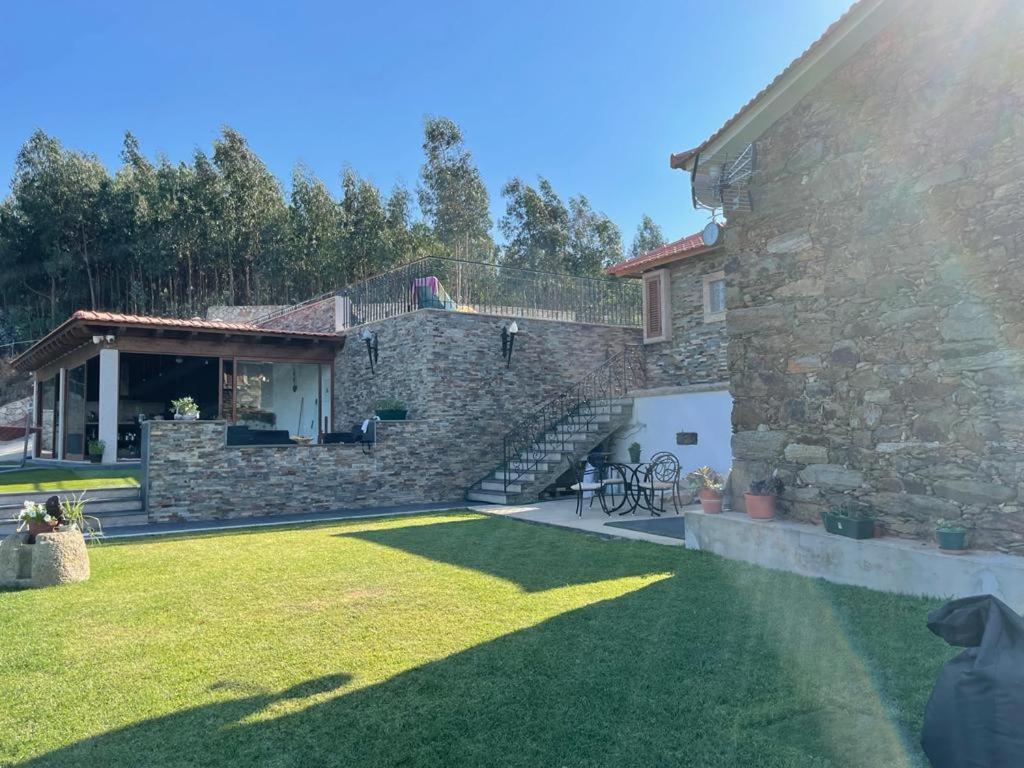 uma casa de pedra com um relvado em frente em Refúgio em Castelo de Paiva