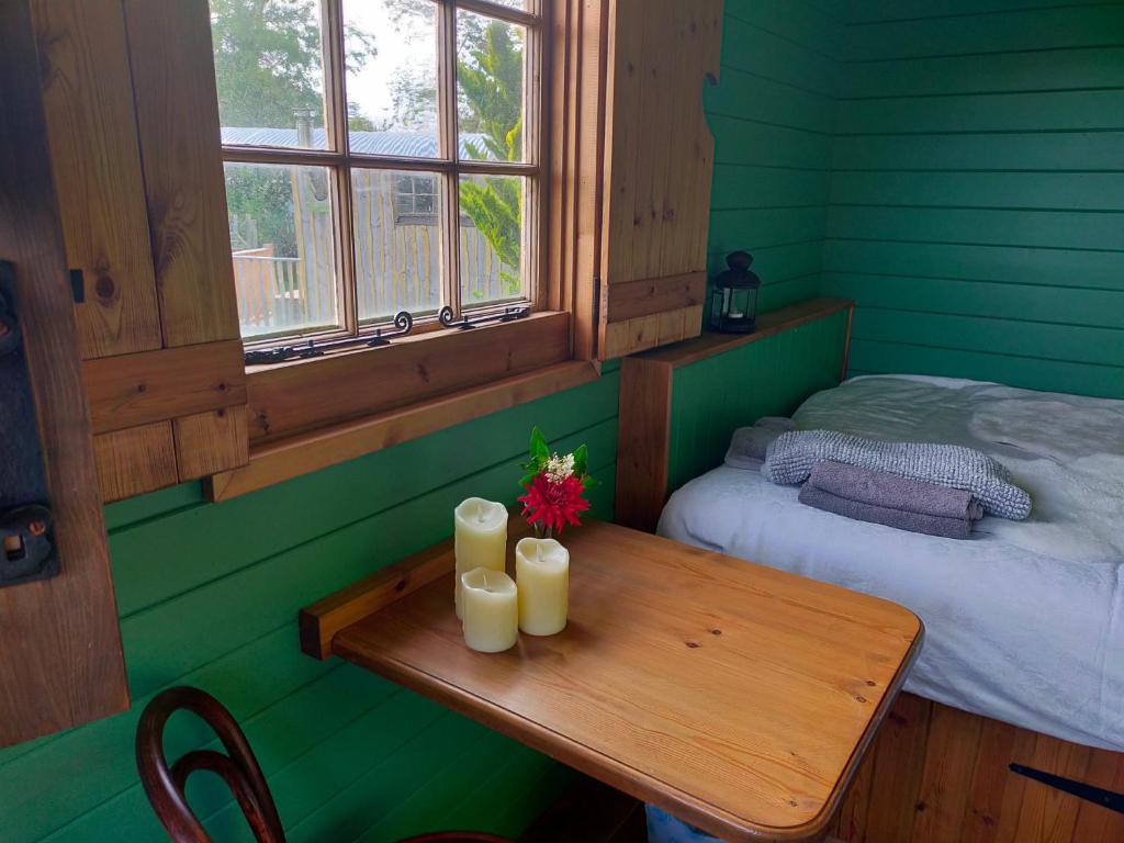 a room with a table with two candles and a bed at Lucker mill shepherds huts in Lucker