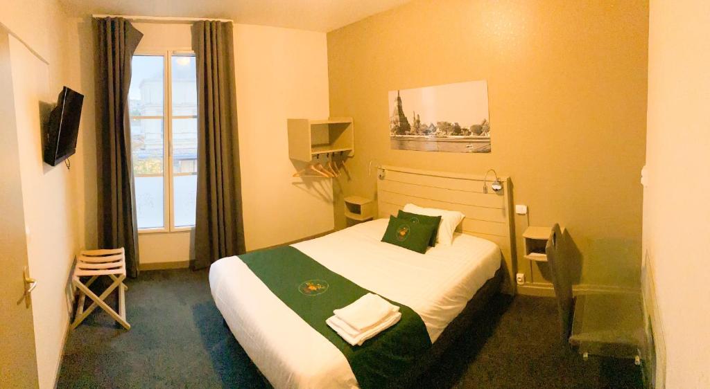 a hotel room with a bed and a window at Colette Hôtel in Niort