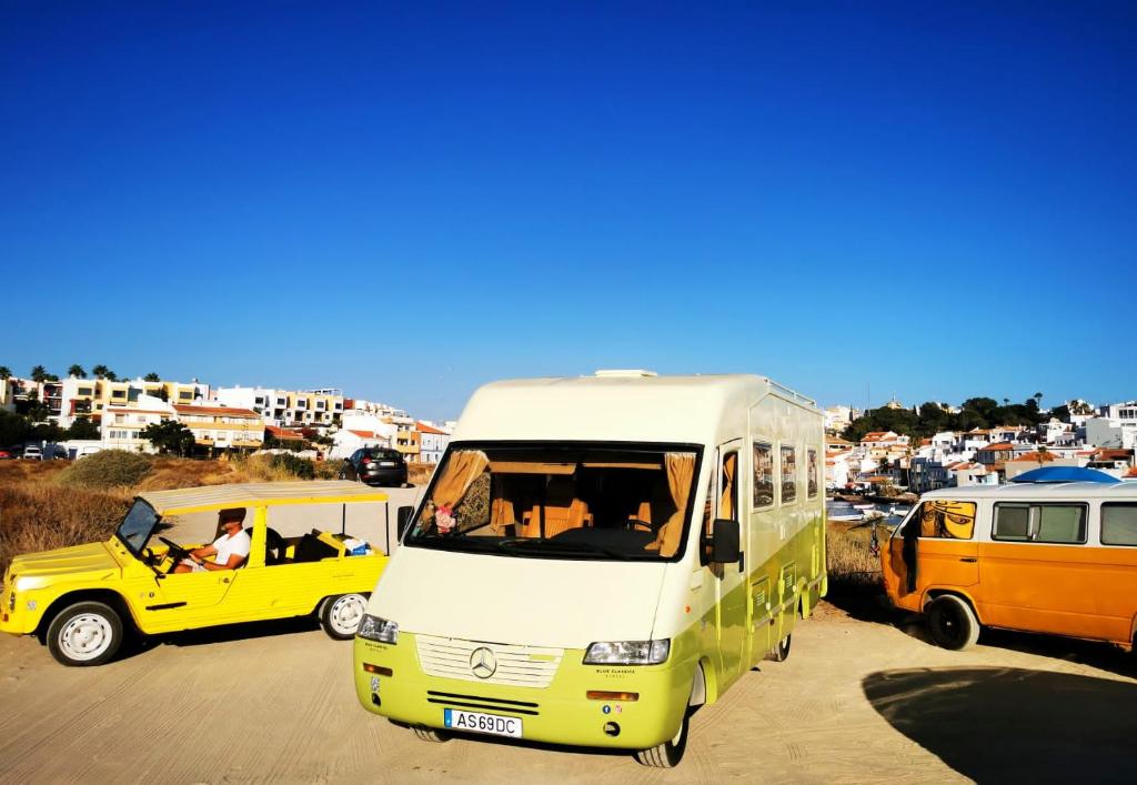 un bus jaune et blanc garé dans un parking dans l'établissement Rent a BlueClassics 's Campervan AUTOSTAR in Algarve au Portugal, à Portimão