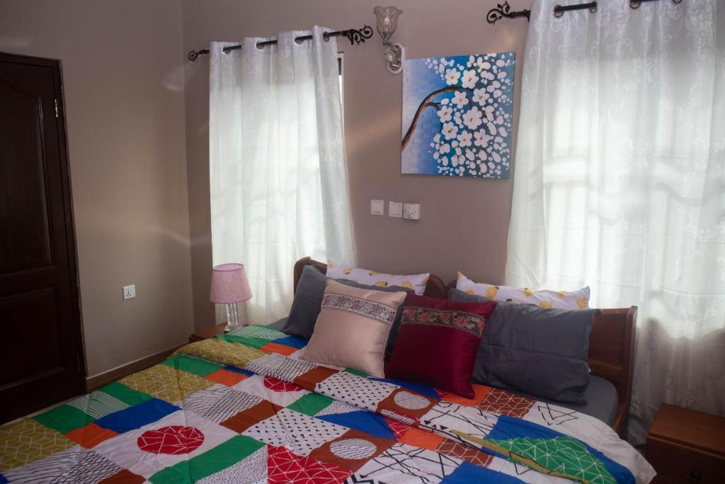 Un dormitorio con una cama con una colcha colorida. en Lurelin Village Apartments, en Accra