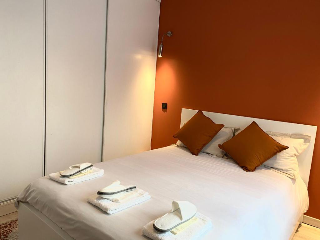 a bedroom with a white bed with two towels on it at Le Voltaire apartment - Paris Center in Paris